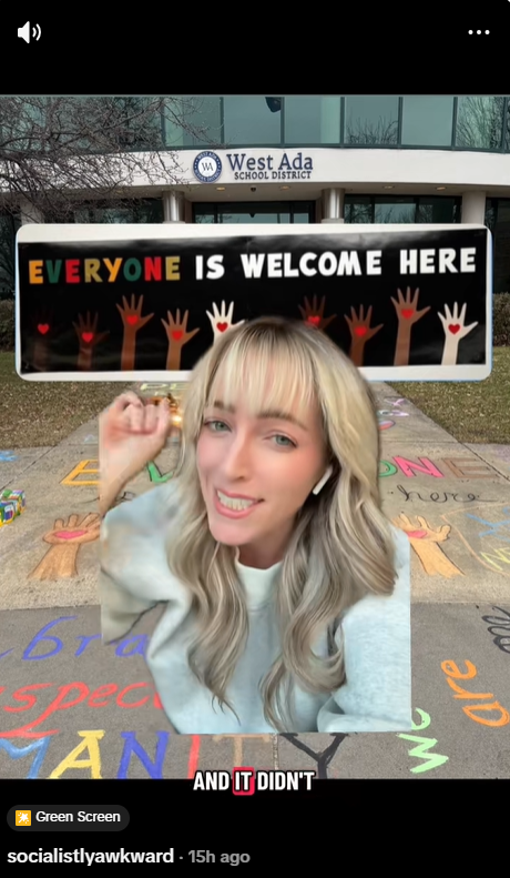 Greenscreen TikTok screengrab of @socialistlyawkward over West Ada School District building, with chalked sidewalk in foreground and Everyone is Welcome Here sign.